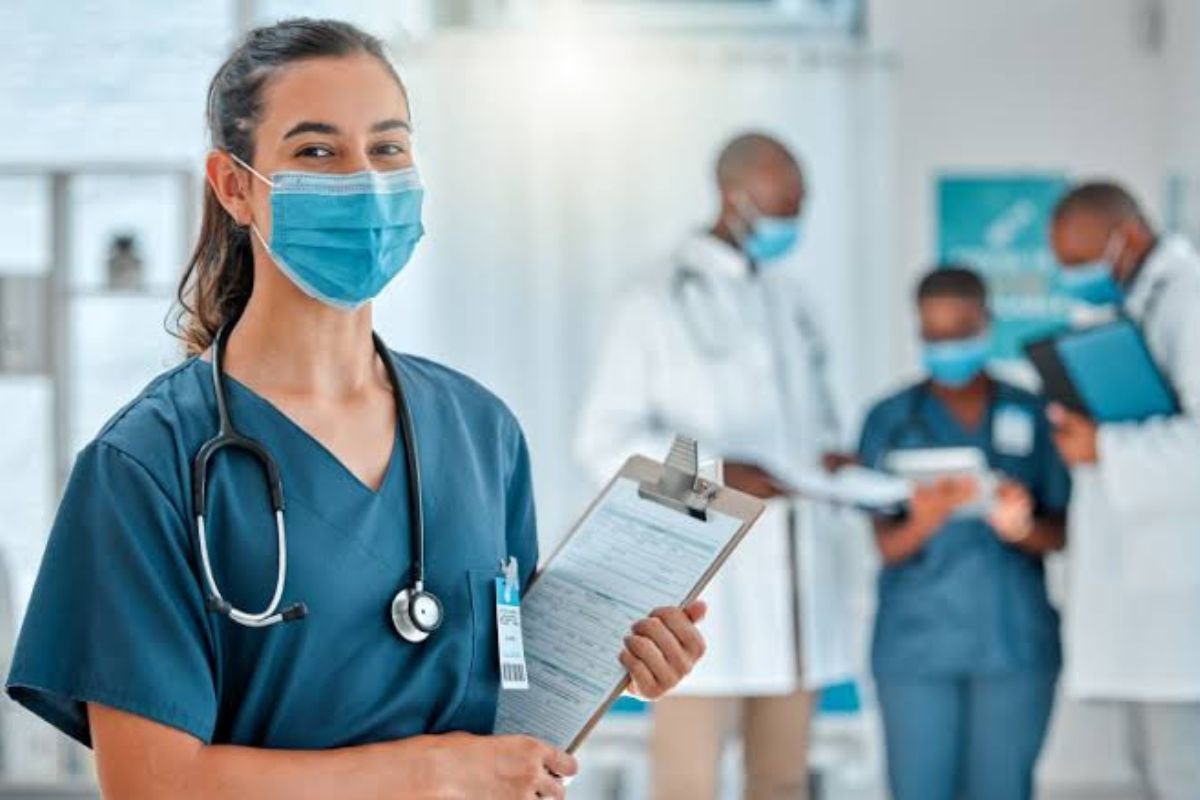 A Nurse standing with pad and apron